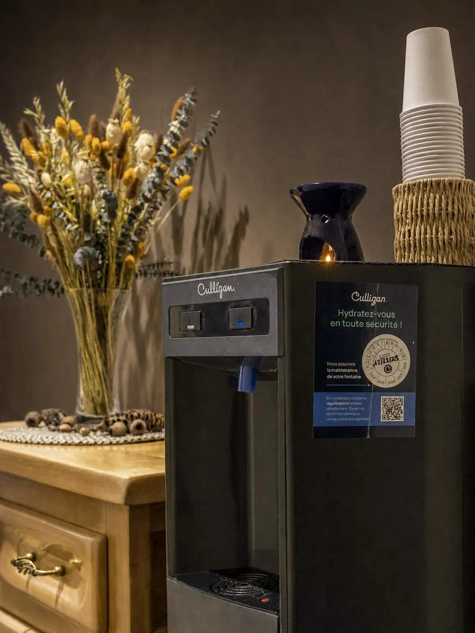 Water dispenser and a bouquet of dried flowers in the reception area of the massage salon in Villeurbanne, near Lyon