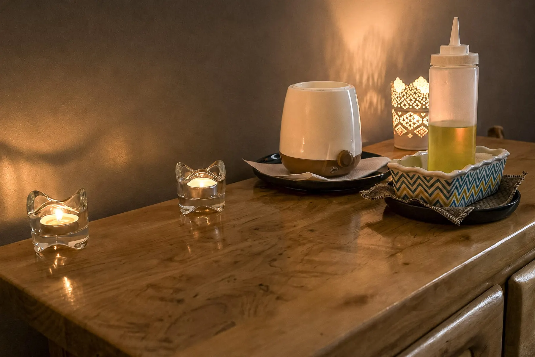 Grape seed oil and candles on the chest of drawers in the massage room in Villeurbanne, near Lyon